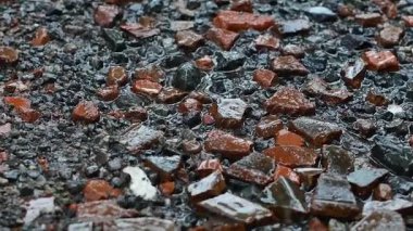 Yağmur damlaları kayalarla dolu yere düştü. Kayalık zemine düşen 4k yağmur suyu videosu.