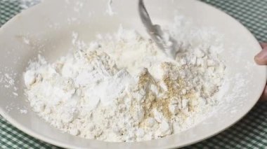 Hamur yapmak için un eleme işlemi. Ölçülü miktarda un bir kabın içine dökülüyor ve elle karıştırılıyor. Yemek yapmak için una baharat karıştırıyorum..