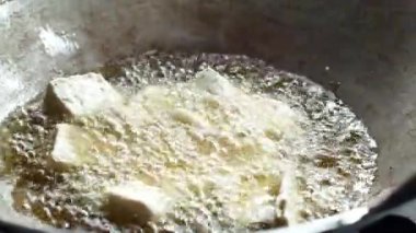 Kavurma yağıyla dolu bir tavada soya peyniri kızartma videosu..