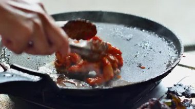 Gaz ocağında ızgara tavada ızgara kırmızı baharatlı tavuk. Sarı zerdeçal baharatlı çiğ tavuk eti, sarımsak ve ızgarada yeşillik pişiriyorum. Kızarmış tavuk dilimi..