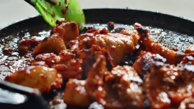 Gaz ocağında ızgara tavada ızgara kırmızı baharatlı tavuk. Sarı zerdeçal baharatlı çiğ tavuk eti, sarımsak ve ızgarada yeşillik pişiriyorum. Kızarmış tavuk dilimi..