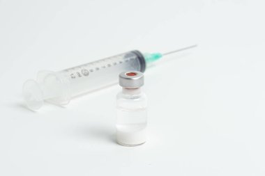 Aşı şişesi ve şırınga beyaz arka planda. Aşı, aşı, Covid-19 tedavisi. Üst Manzara. Yakın plan. Boşluğu kopyala.