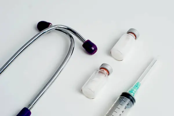 Aşı şişesi ve şırınga beyaz arka planda. Aşı, aşı, Covid-19 tedavisi. Üst Manzara. Yakın plan. Boşluğu kopyala.
