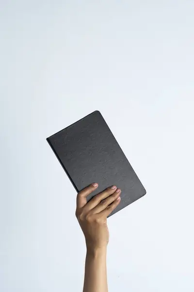 İnsanların elleri kitapları tutuyor. Beyaz izole edilmiş arka planda bir kadının el bilgisayarı..