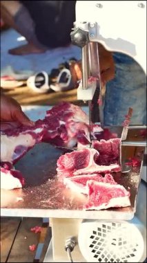 Kasap eti özel bir testere makinesiyle keser. Özel et testeresi makinesiyle kesilmiş sığır eti. Kurban Bayramı 'nda bir makineyle et kesme olayı.