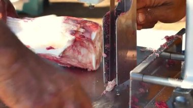 Kasap eti özel bir testere makinesiyle keser. Özel et testeresi makinesiyle kesilmiş sığır eti. Kurban Bayramı 'nda bir makineyle et kesme olayı.