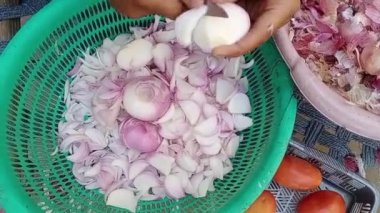 Asyalı kadın soğan dilimleri kesiyor ya da yemek pişirmek için sebze sepeti kesiyor. Hızlı soğan doğrama
