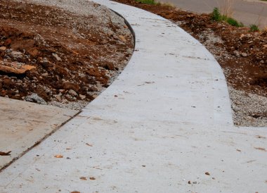 Yeni bir kaldırım inşaatı. Çamur yığınlarını ve garaj yolunun köşelerini gösteriyor.