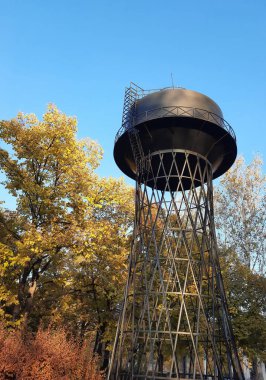 Sonbahar parkının çatısında eski metal kule.