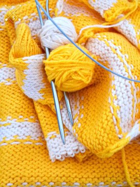 Örgü süveter, sarı örgü iğneleri ve örgü iplikleri..