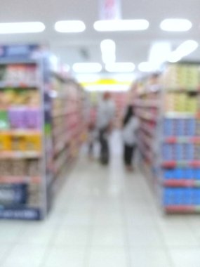 Alışverişçilerin odaksız görüntüsü raflarla dolu marketlerde geziniyor.