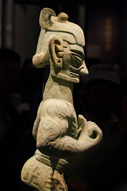 Guanghan Çin - 24 Mayıs 2024: Çin 'in Sichuan Eyaleti, Chengdu yakınlarındaki Sanxingdui Müzesi' nde düzenlenen sergide, MÖ 12. yüzyıldan kalma etekli bir erkek bronz figür el ele tutuşuyor..