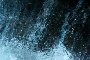 Dağ nehrinin şelalesindeki suyun beyaz, mavi, siyah yansımaları.