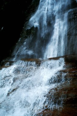 Bir dağ nehrindeki şelalelerdeki yansımalar ışığa karşı uzun süre fotoğraflanmış.