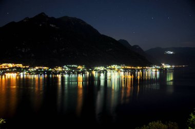 Gece Como Gölü 'nde yansıyan şehirlerin ışıklarının yansımaları.