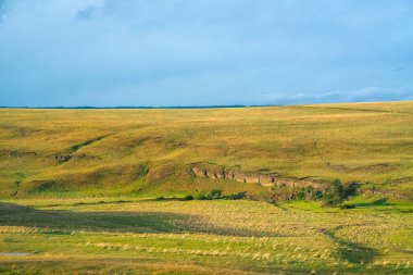 Arjantin Patagonya 'nın uçsuz bucaksız topraklarında bulutlarla ve mavi gökyüzüyle güzel bir manzara.