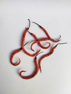 Beyaz arkaplan ile uzun kırmızı biber, baharatlı bir tadı var ve baharat olarak eklenmeye uygundur..