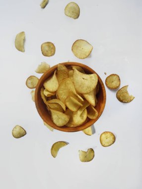 Ahşap bir kasede beyaz arka planda Cassava cipsleri..