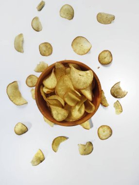 Ahşap bir kasede beyaz arka planda Cassava cipsleri..