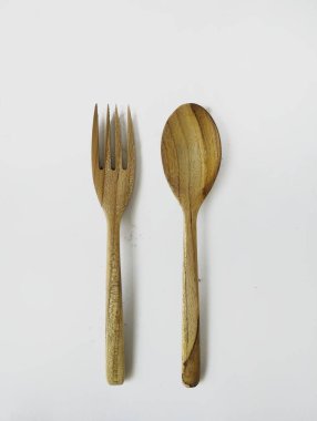 Tahta kaşık ve çatal, beyaz bir arka plan.