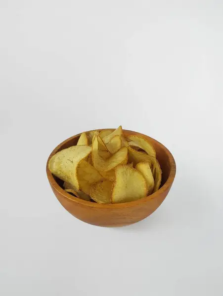 stock image Cassava chips in a wooden bowl with a white background.