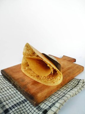 Leker keki, buğday unu ve sıcak tabakta pişirilmiş esmer şekerden yapılan geleneksel bir Java yemeğidir. Beyaz arkaplanı olan pırasalı pasta..