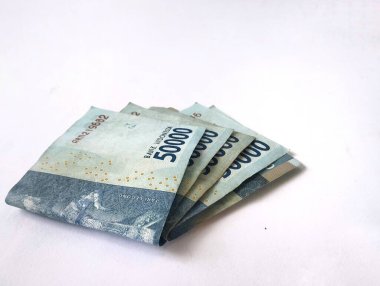 50.000 rupia 'lık birkaç yaprak, Endonezya' nın para birimidir. Beyaz bir arka planı vardır..