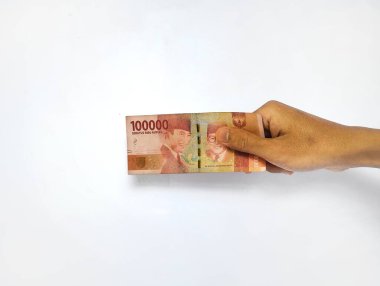 Birkaç Endonezya banknotuyla el ele tutuşmuş, 100.000 Rupiah değerinde ve beyaz bir geçmişi var..