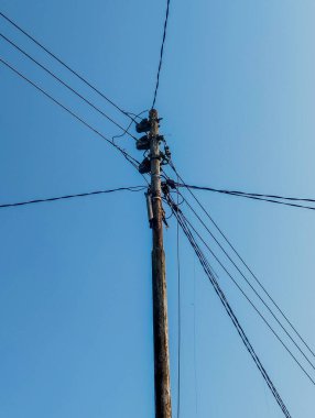 Mavi gökyüzü arka planına sahip elektrik direği - her eve elektrik dağıtmak için kullanışlı.