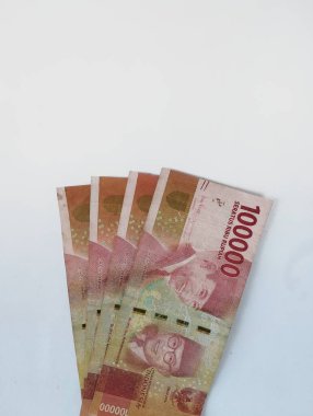 100.000 rupia 'lık birkaç yaprak, Endonezya' nın para birimidir. Beyaz bir arka planı vardır.