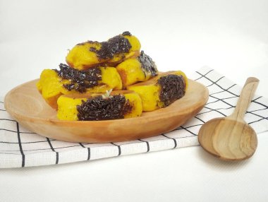 Tahta tabakta çikolata aromalı kusmuk keki ve beyaz arka planda izole edilmiş kareli taban.. 