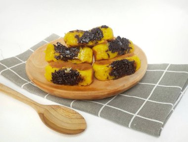 Tahta tabakta çikolata aromalı kusmuk keki ve beyaz arka planda izole edilmiş kareli taban.. 