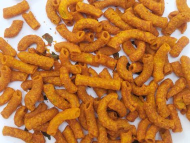 Baharatlı makarna beyaz bir zemine saçılmış, gıda ürünleri için uygun bir arka plan..