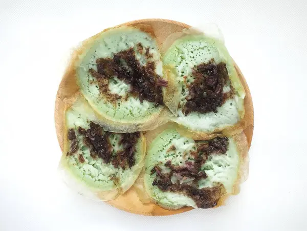 stock image Serabi solo cake on a wooden plate, isolated on a white background - serabi solo is a typical Indonesian food that has a soft and sweet texture. 