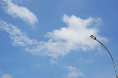 minimalist style photo, lamp post lighting with cloudy blue sky background clipart