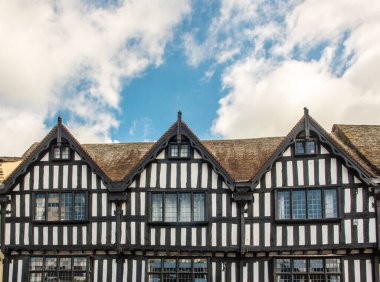 Tudor mimarisi. Shakespeare 'in memleketi Stratford-upon-Avon, İngiltere' de arka arkaya siyah-beyaz yarı keresteli evlerin üst kısmı. 16. yüzyıldan resimli İngiliz Jacobean ya da Elizabeth tarzı. 