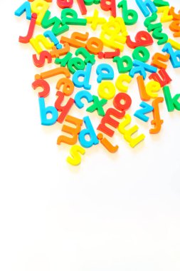 Beyaz izole arkaplana dağılmış renkli alfabe harfleri ve alttaki boşluğu kopyalayın. İletişim, konuşma, yazma, kelimeler, konuşma, okuma, edebiyat, öğrenme kavramı. Dikey resim