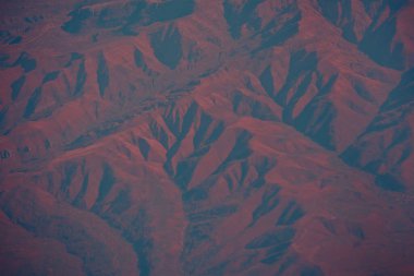 Dağ vadisinin soyut arka plan drone görüntüsü sürreal koyu kırmızı kahverengi kestane rengi. Ekstrem arazi gezegeni. Rocky Vadisi 'nde dağ yürüyüşü. Yukarıdan gelen toprak. Mars ortamı.