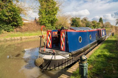 İngiltere seyahati - geleneksel eski kanal teknesi Warwickshire, Shakespeare County 'de demirliyor. Alternatif turist eğlencesi. Londra 'dan Midlands' a kadar Büyük Birlik Kanalı 'nda resim gibi dar bir tekne..