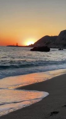 Kumsalda gün batımı ve dalgalar