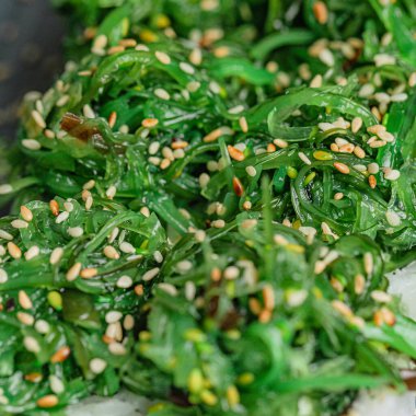 Canlı ve besleyici bir yemek sergilenen tabakta çeşitli taze yeşilliklerin detaylı bir görüntüsü.