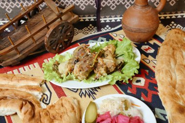 Lezzetli yiyeceklerle dolu çeşitli tabaklar ve yanında taze pişmiş ekmeklerle dolu bir masa..