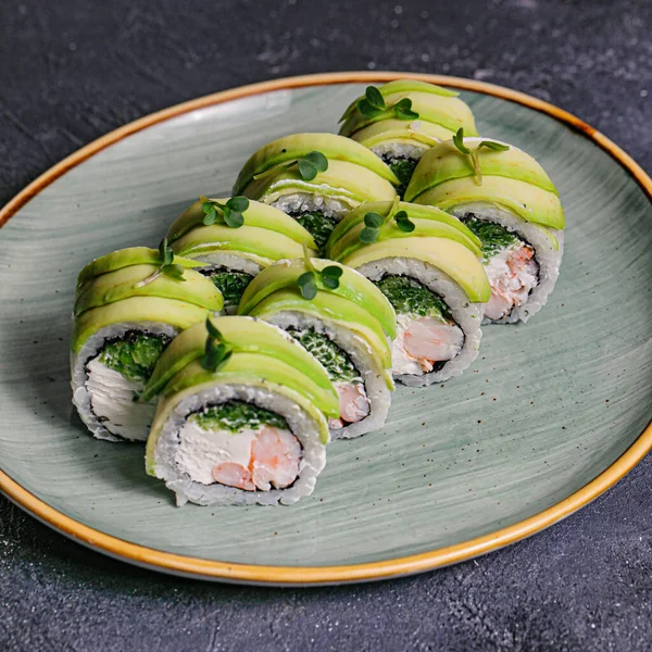A plate filled with a variety of sushi rolls, including fresh broccoli and creamy avocado, creating a delicious and healthy meal.