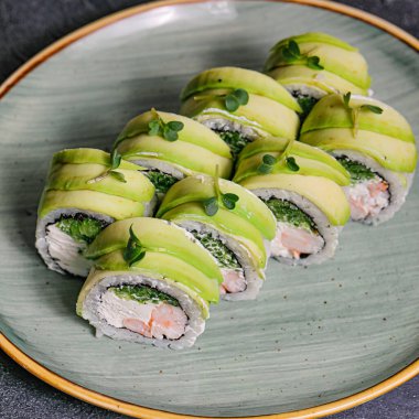Bir tabak suşi, çeşitli yeşil sebzelerle süslenmiş çeşitli dürümler ve nigiri..