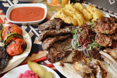 Bir masa bir kase sosla birlikte birden fazla yemek tabaklarıyla süslenir..