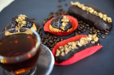 Çeşitli hamur işleriyle süslenmiş bir masa ve yanında da dumanı tüten bir fincan kahve..