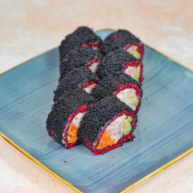 Mavi bir tabakta iki parça suşi. Narin ve iştah açıcı sunumu sergileniyor..