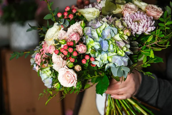 A person holds a bouquet of flowers in their hands, with copy space.