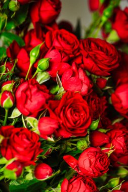 Fotokopi alanı olan bir masada güzel bir kırmızı gül aranjmanı..