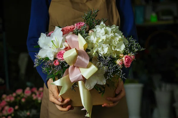 A person holds a bouquet of flowers in their hands against a copy space.